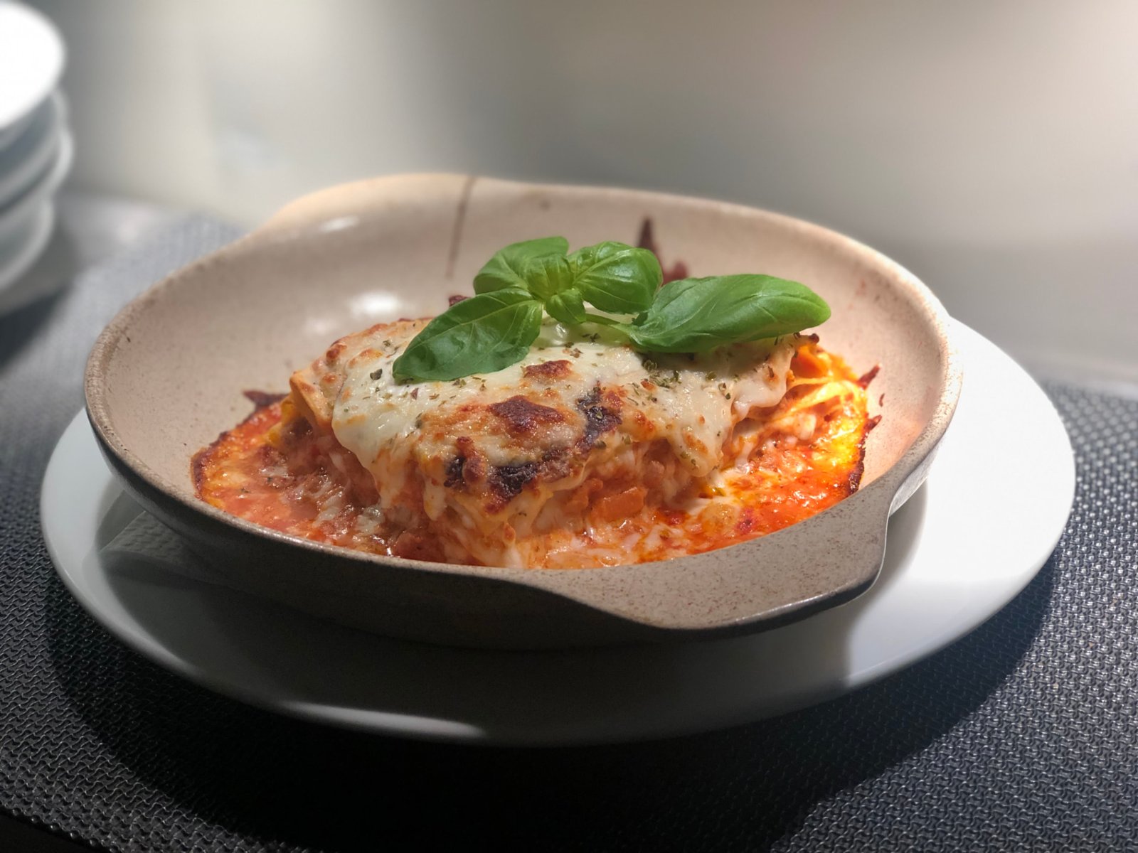 Lasagne clássica de carne gratinada com queijo mozzarella e manjericão fresco