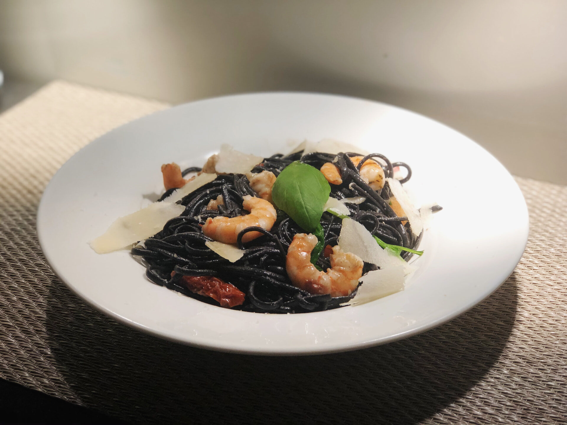 Prato de massa negra com gambas servido no Massarella